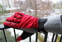 Red Sealskinz winter cycling glove on a snowy backdrop