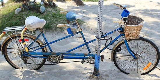 Picture taken on Venice Beach in LA of a blue tandem bike in the sand
