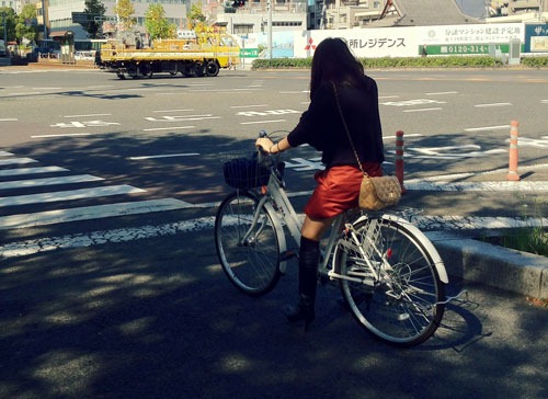 Cyclist waiting at a traffic light in Japan