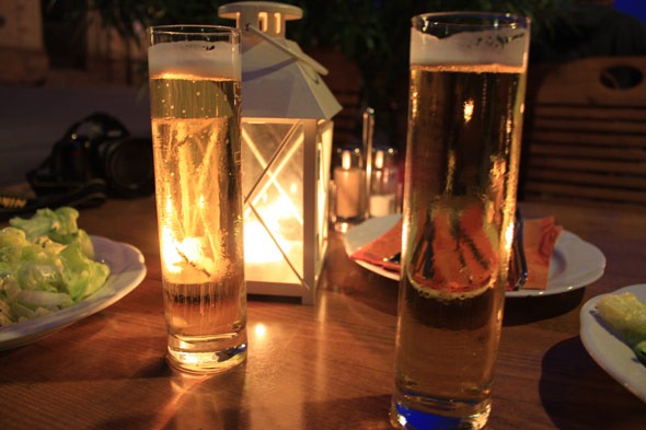 Beer on the table next to a candle