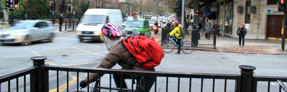 Two female cyclists wait at the traffic light