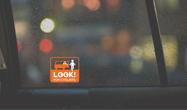 Sticker to look out for cyclists which is placed in the window of a taxi