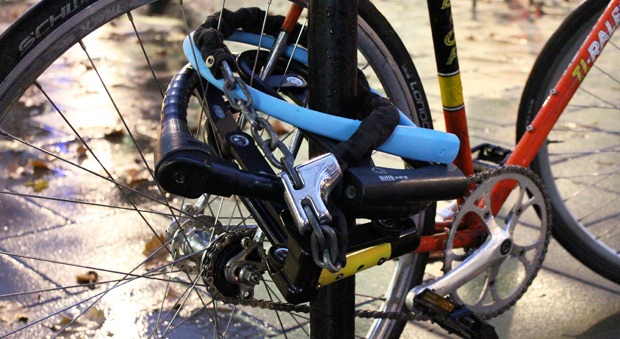 7 bike locks around a back wheel and a cycling stand
