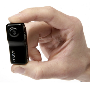 Veho Muvi helmet camera held by a hand to show how small it is