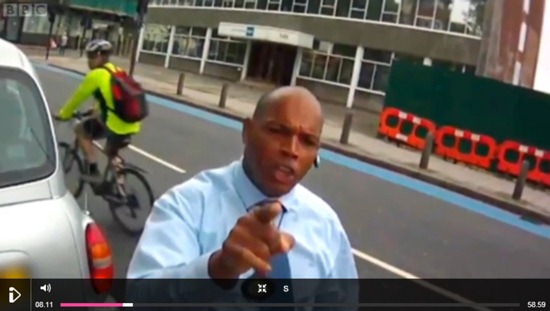 An angry motorist pointing their finger at a camera