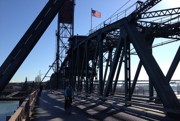 A cyclist passes over a bridge in Portland